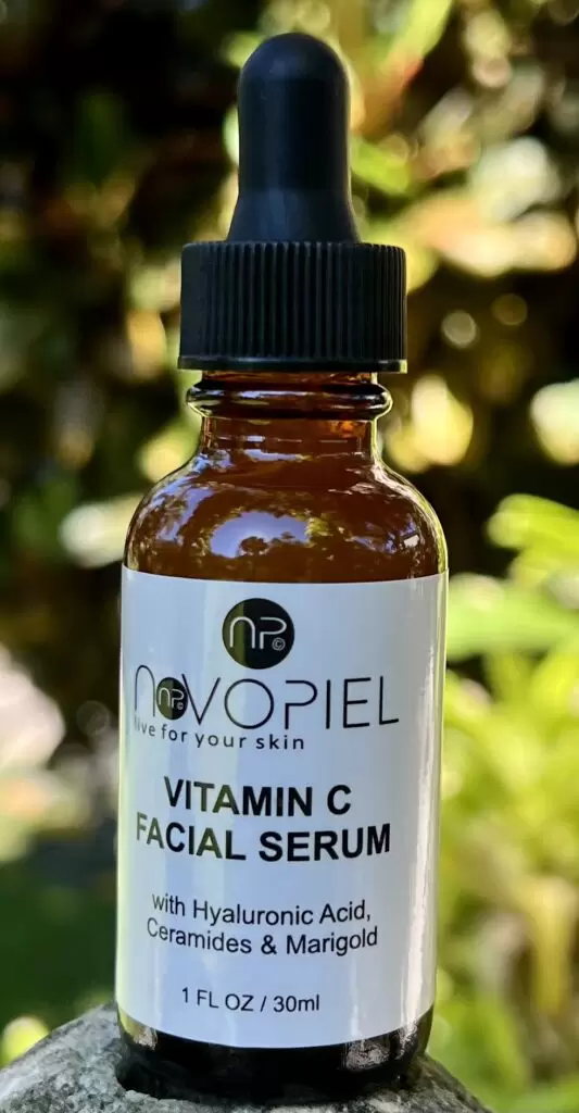 Vitamin C facial serum with hyaluronic acid, ceramides, and marigold in a dropper bottle, highlighting skincare benefits.